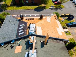 While repairing roof of apartment building, old shingles replaced plywood and new shingles were installed.